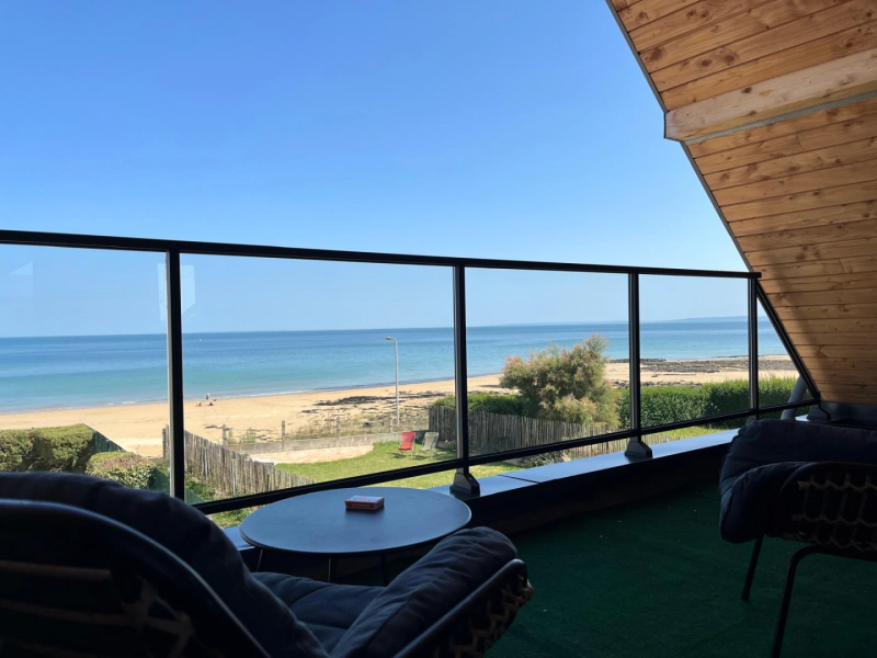Garde-corps vitré à cadre noir sur terrasse avec vue mer