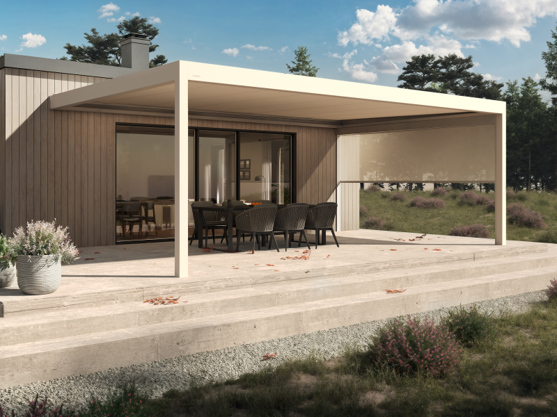 Pergola crème adossée à une maison bois, terrasse béton et salon de jardin