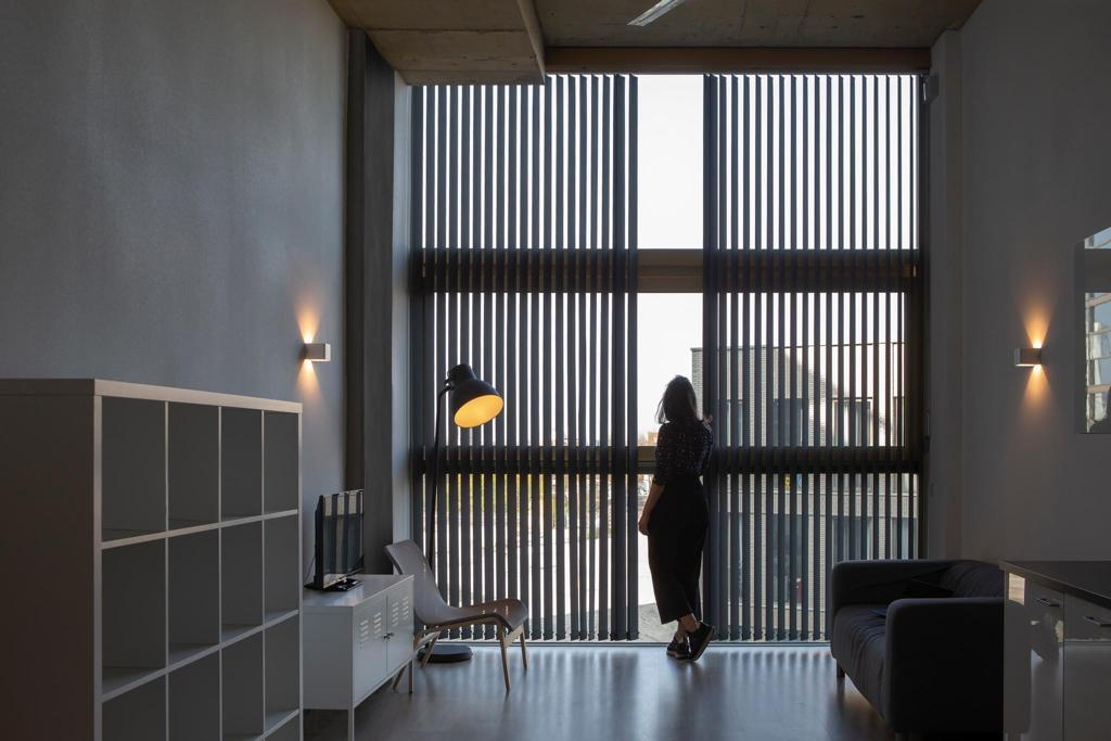 Store californien à bandes verticales noires sur grande baie dans un salon